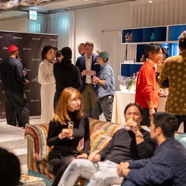 party scene of people standing and talking with some sitting in the foreground