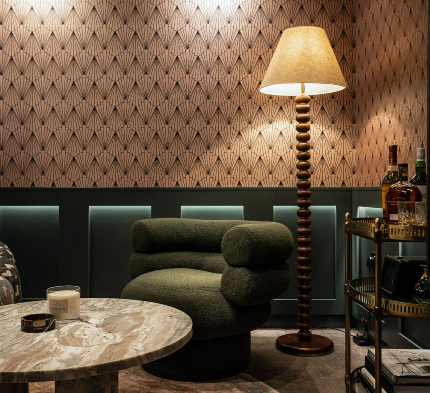 a dark green couch in a well appointed room with a bar cart