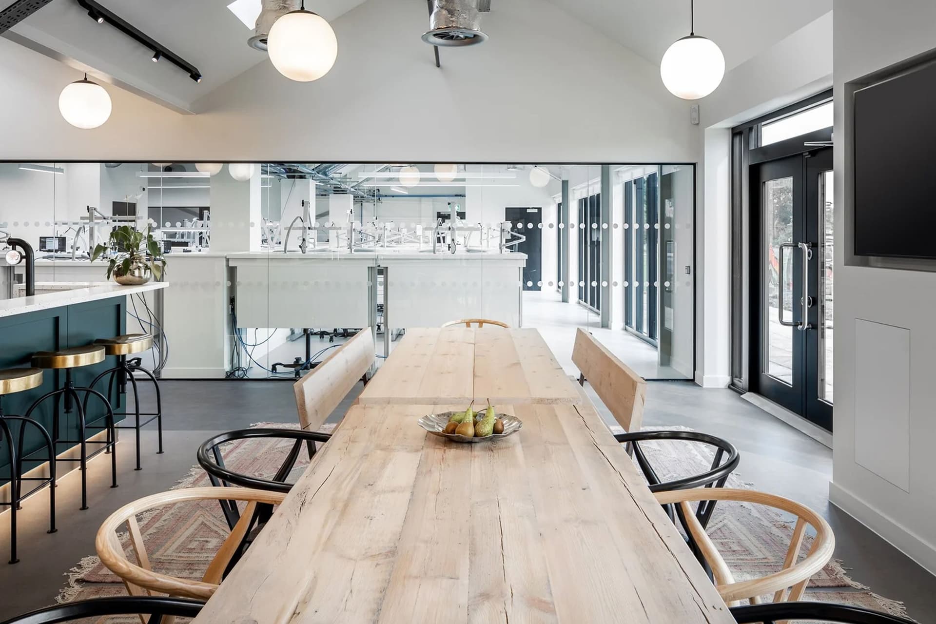 brightly lit showroom with a long farm style table and high chairs