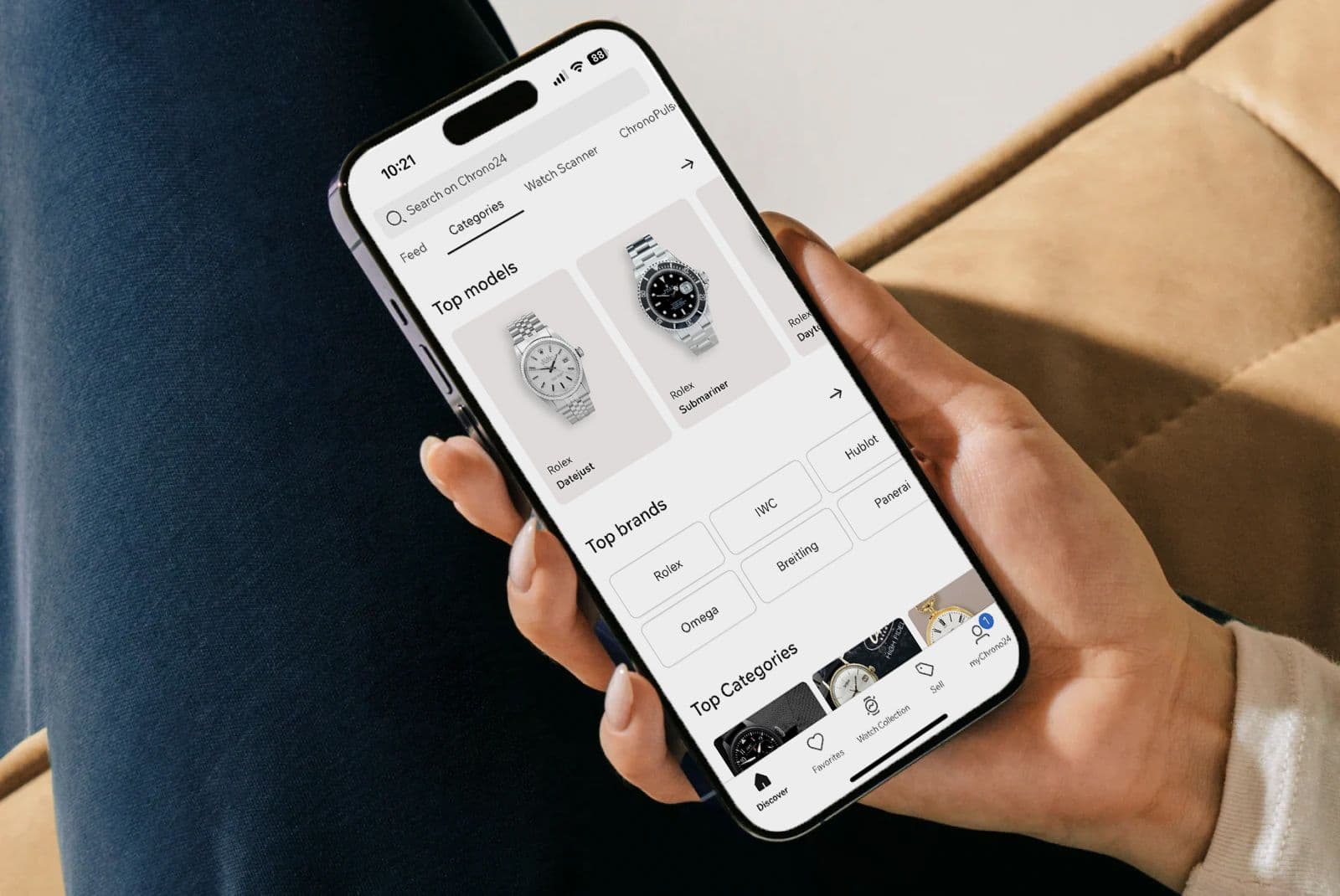 Hand holding a smartphone showing a watch marketplace app with top watch models.