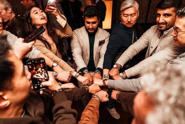 group of people posing with their wrists in a big circle