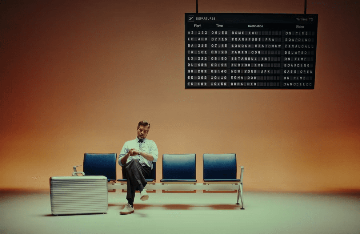 a man is sitting in the airport and looking his watch